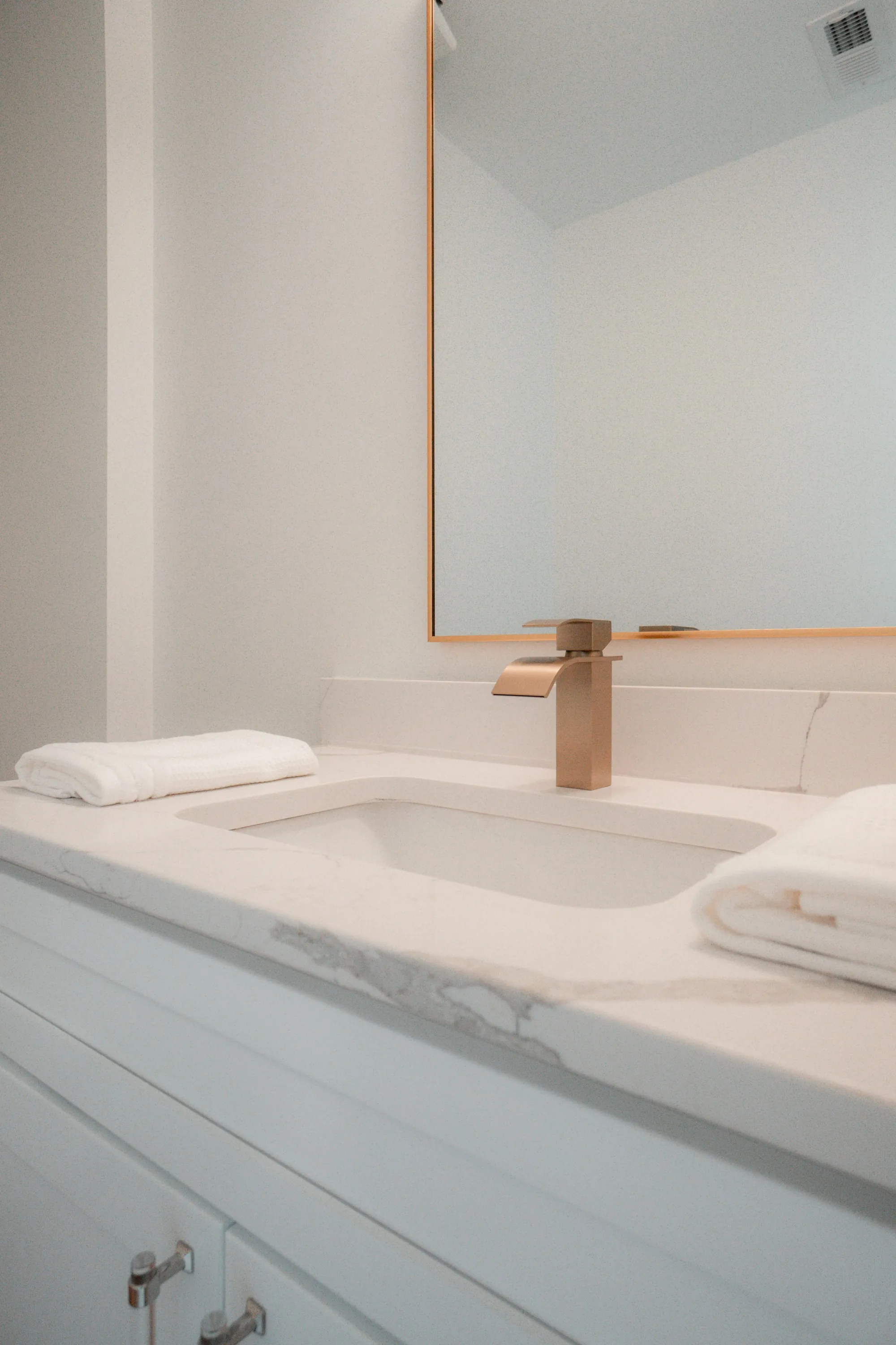 A clean home bathroom with a towel beside the basin