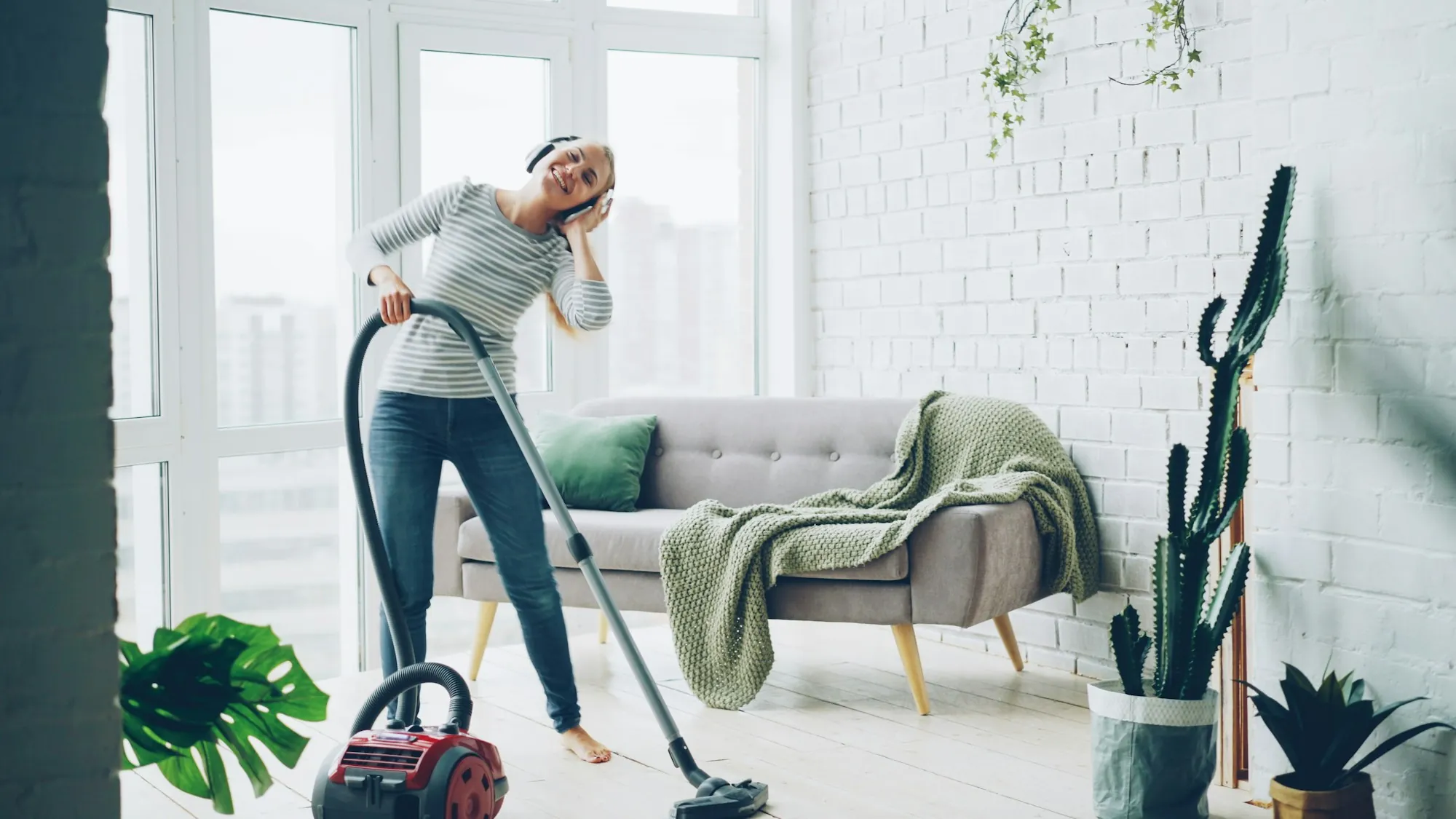 A woman vacuuming a bright living room