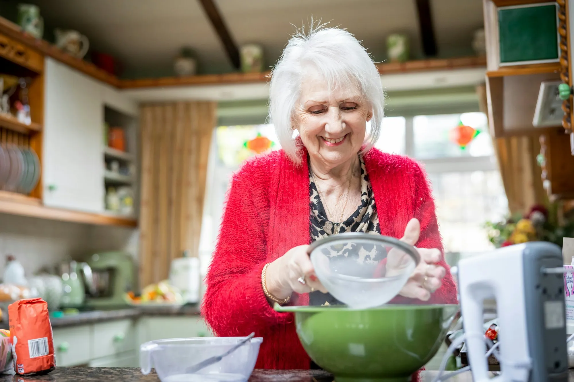 An older woman preparing food in her kitchen
