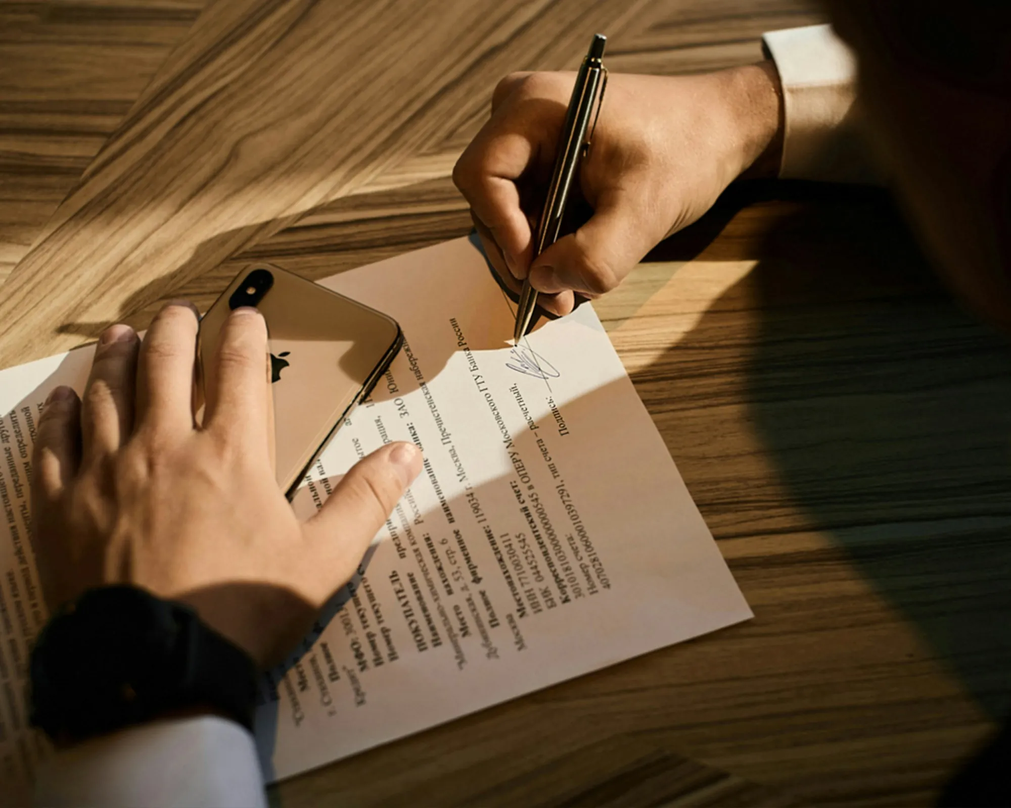 A hand writing on a sheet of paper with a pen
